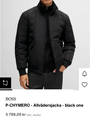 Svart vindjacka från BOSS - Stilren svart vindjacka från BOSS med hög krage och dragkedja framtill. Jackan har ribbade muddar vid ärmslut och nederkant samt diskreta sidofickor. Materialet är slätt och lätt, perfekt för blåsiga dagar. Klassisk och minimalistisk design. Använd 2 gånger, så i princip nyskick. Hör av er vid fler frågor!  