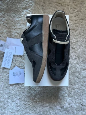 Maison Margiela Gats - Säljer ett par sjukt snygga maison margiela gats i storlek 43. De är i princip i nyskick och allt og följer med som box,dustbag osv. Nfc på sulan under skon fungerar och farfetch tag följer med. Kvitto finns likaså. Skriv vid frågor eller funderingar! Fraktar inom 24 timmar (instabox).