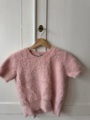Ljusrosa fluffig topp från Zara - Supermjuk och fluffig kortärmad stickad tröja från Zara i en ljusrosa färg. Storlek L ( mycket liten i storlek, snarare en XS ) . Fint skick!