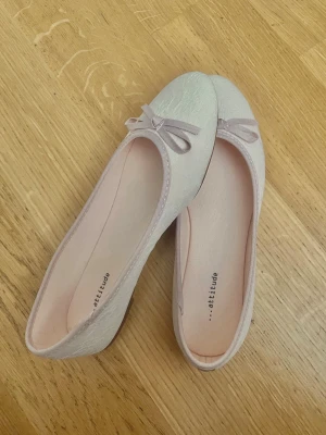 Ljusrosa ballerinaskor med rosett - Söta ljusrosa ballerinaskor från Attitude med liten rosett framtill. Skorna har en diskret spetsmönstrad yta och rundad tå. Har aldrig använt de, nypris 249:- ☺️🩷