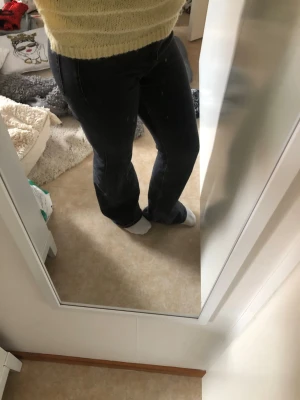 Svarta bootcut jeans med hög midja - Säljer dessa svarta/mörkgråa jeans då det är förstora på mig, det är en högre midja som går till under naveln ungefär. De är slitna längst ner(se bild)