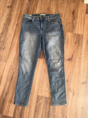 Levi’s Jeans - Snygga blå slim fit jeans med lätt slitna detaljer och klassisk femficksdesign. Jeansen har normal midja och smala ben, perfekta för en avslappnad och trendig look. Materialet är stretchigt för extra komfort.