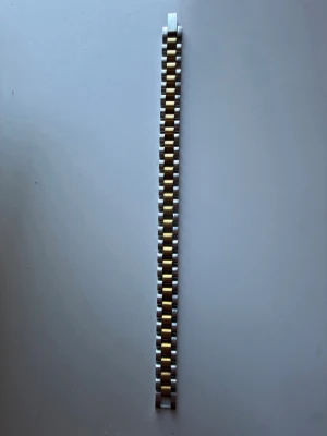  länkarmband  - Snyggt länkarmband  i silver och guld. Armbandet har en klassisk design med rektangulära länkar i metall och passar perfekt för dig som vill byta stil på din klocka. Enkel att fästa och ger en exklusiv känsla.