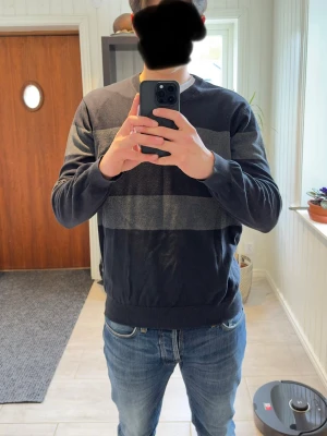 Race Marine stickad tröja svart/grå strl L - Stickad tröja från Race Marine i svart och mörkgrå randig design. Mjuk och bekväm med clean passform som passar perfekt till både vardag och mer uppklädda outfits. Storlek L. Bra skick.  Modellen på bilden är ca 185 cm lång och väger ca 78 kg för referens.