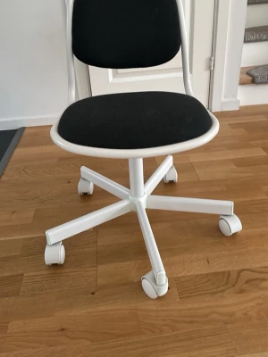 Svart och vit snurrstol med hjul - Säljer en stilren snurrstol med svart sits och ryggstöd, samt vit ram och ben med fem hjul. Perfekt till skrivbordet eller plugghörnan. Stolen har en enkel och modern design i plast och tyg.