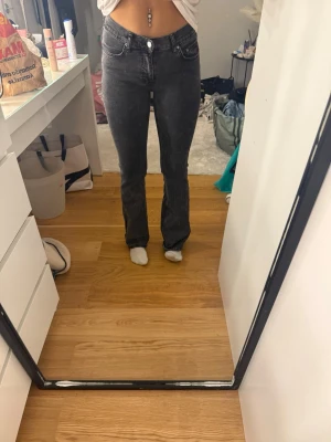 Gina tricot jeans  - Snygga svarta bootcut jeans med medelhög midja och klassisk femficksdesign. Jeansen har en lätt tvättad look och stängs med knapp och dragkedja. Perfekta för dig som gillar en trendig och bekväm passform. Nypris 500kr