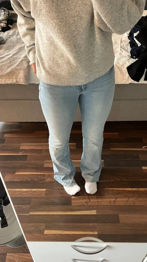 Ljusblå bootcut jeans - Säljer ett par ljusblå bootcut jeans med snygg broderad detalj i rosa och vitt på bakfickan. 