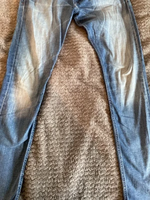 Blå diesel jeans - Snygga blå slim fit jeans med bakfickor med dekorativa sömmar. Jeansen har klassisk femficksdesign och är tillverkade i denim med lätt stretch för skön passform.     Diesel.   W32.   L32