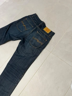 Blå Nudie jeans antagligen ”Grim Tim” - Tjenare, säljer nu mina extremt snygga Nudie jeans i grim trim tror jag, då lappen där i är för sliten för att se, tror även att det är 30:32 men hör av dig för mått 👍