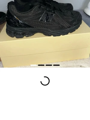 Svarta New Balance sneakers - Säljer ett par helsvarta New Balance sneakers med cool textur i materialet och klassisk N-logga på sidan. Skorna har en chunky sula och är tillverkade i en mix av mesh och syntet. Perfekta för dig som gillar streetwear och vill ha något som sticker ut.