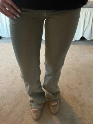 Olivgröna bootcut jeans från Nelly - Säljer ett par olivgröna jeans från Nelly med bootcut passform och klassisk femficksdesign. Jeansen har en snygg detaljsöm på bakfickan och är gjorda i slitstarkt bomullstyg. Perfekta för en chill och trendig stil.