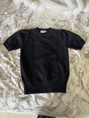 Mörkblå kortärmad topp från Saint Tropez - En stilren mörkblå topp från Saint Tropez (åhlens) med korta ärmar och rund hals. Toppen har en ribbad nederkant🥰