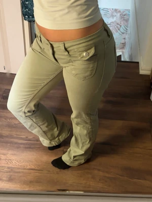 Gröna low waist bootcut jeans - Säljer ett par gröna low waist jeans med bootcut-modell. Materialet är stretschigt och jenasen har jätte fin pass form. Andvända enbart 1-3 tilfällen säljer då det tyvärr inte riktigt är min stil. Strl 34/short. Hör av er vid fler frågor🤗
