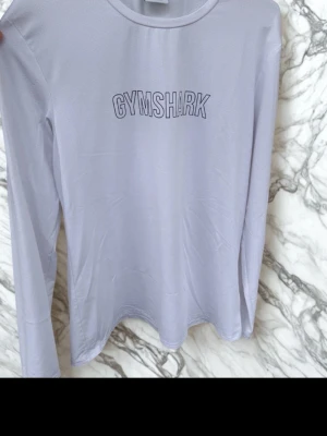 Gymshark (vit långärmad) - Vit långärmad tröja från Gymshark i lätt och stretchigt material. Perfekt för träning eller en sportig look. Storlek L mycket bra skick!