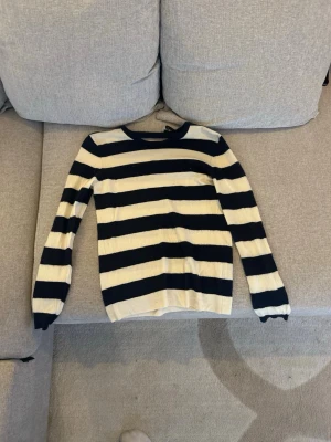 Randig stickad tröja Dolce & Gabbana - Snygg stickad tröja från Dolce & Gabbana med breda marinblå och vita ränder. Tröjan har rund halsringning och långa ärmar. Perfekt för dig som gillar klassisk och tidlös stil. Materialet Kashmir, mjukt och bekvämt.