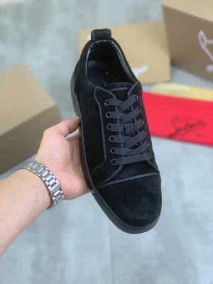 Svarta Christian Louboutin skor - Stilrena svarta sneakers i mocka från Christian Louboutin med klassisk röd sula och svarta skosnören. Låg modell med diskreta sömmar och ikonisk design. Perfekta för dig som vill ha en clean look med exklusiv känsla.