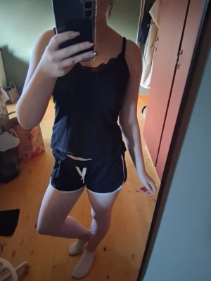 Svarta shorts med vit snörning💕 - Säljer ett par svarta shorts med vit snörning och vita kanter. De har en sportig look och är perfekta för sommaren. Shortsen har elastisk midja och är tillverkade i mjukt material för maximal komfort.💕