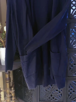 Kofta - Mysig mörkblå kofta i mjuk velour med två stora fickor framtill . Perfekt för att chilla hemma och hålla sig varm under kalla dagar Enkel och stilren design utan synligt märke.