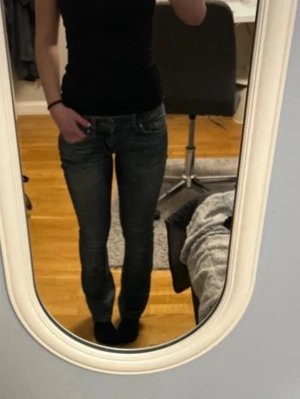 Mörkblå bootcut jeans - Snygga mörkblå bootcut jeans med lätt slitning och klassiska fem fickor. Jeansen har låg midja och lätt utsvängda ben. Perfekta för en avslappnad och trendig look.