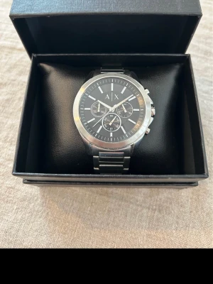 Armani Exchange Chrono 44mm Herrklocka - Säljer Säljer en snygg kronograf herrklocka från Armani Exchange i nyskick. Ser nästan oanvänd ut. Fungerar bra, 18cm originalarmband i stål, datumvisare, vattentät, kronograf, japanskt urverk osv. Behöver bara nytt batteri. Fås i snygg klocklåda med läderkudde (ej original). Modell: AX2600.  Nypris: 1500 SEK Begagnat pris: 1300 SEK Mitt pris: 589 SEK  Skickas alltid spårbart och snabbt (ofta samma dag) eller hämtas i Glumslöv.  Hör av dig vid frågor och se gärna mina andra annonser också!