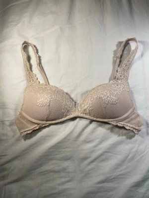 Beige spets-bh från Intimissimi - Säljer en beige bh från Intimissimi med vadderade kupor och vacker spetsdetalj över hela framsidan och axelbanden. Bh:n har justerbara axelband och hakknäppning bak. Skriv om du har några frågor❤️