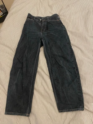 Mörkblå barrel jeans - Snygga mörkblå jeans med rak passform. Jeansen har hög midja och loose fit. Storlek 34 köpta på H&M