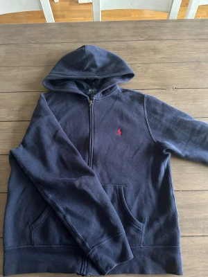 Mörkblå Ralph Lauren Zip Up - Tjenare! Säljer denna Ralph Lauren zip up då den blivit för liten, den har använts ett par gånger men har inga som helst tecken på användning! Det är bara skriva till mig om ni har några frågor eller funderingar, priset går att diskuteras🙏❤️