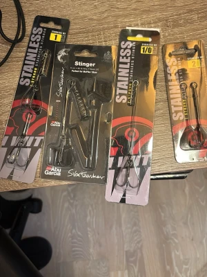 Fisketillbehör från Abu Garcia pris är inte spikat - Flera paket med fisketillbehör från Abu Garcia och Svartzonker. Innehåller stingers och rostfria fjäderringar i olika storlekar, perfekta för predatorfiske. Produkterna är svarta och silverfärgade och levereras i originalförpackning.