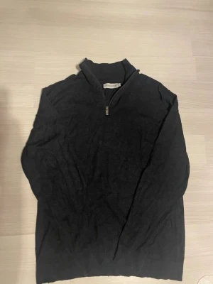 Stickad halfzip - Snygg mörkblå stickad tröja från Les Noble Denmark med halv dragkedja och hög krage. Perfekt för lager på lager och enkel att matcha med olika outfits. Tröjan har en klassisk passform och ribbade detaljer vid kragen. Skriv privat ifall ni vill se den på. Nypris 699 kr