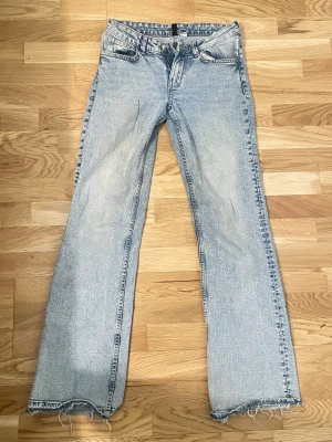Ljusblå raka jeans med råa kanter från H&M - Ljusblå jeans med rak passform och trendigt råa, fransiga benslut. Klassisk femficksmodell och normal midja. Perfekta för en avslappnad och cool stil. Tillverkade i denim med snygg tvättad effekt.