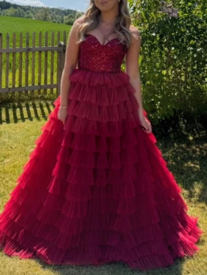 Röd balklänning - Säljer en fantastisk röd balklänning med hjärtformad urringning och glittrande överdel. Kjolen har flera lager av volanger i tyll som ger ett dramatiskt och elegant intryck. Perfekt för dig som vill sticka ut på balen! Balklänning / klänning perfekt till bröllop.  Finns att hämta upp i Jönköping eller evt fraktas Säljs för 3500kr, pris kan diskuteras vid snabb affär Storlek 34/36  Hör av dig vid frågor 🥰🥰