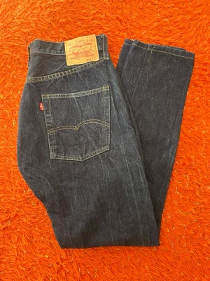 Levi's mörkblå raka jeans, pris kan diskuteras  - Storlek W33 L32, pris kan såklart diskuteras. Klassiska mörkblå jeans från Levi's med rak passform och fem fickor. Jeansen har tydliga kontrastsömmar och den ikoniska läderpatchen bak i midjan. Tillverkade i slitstark denim med Levi's röda etikett på bakfickan.