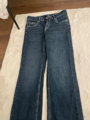 Blå bootcut jeans från Kappahl - Snygga blå bootcut jeans från Kappahl med klassisk femficksmodell och kontrastsömmar. Säljer dom eftersom jag aldrig använt dom tidigare och passar inte in i de.