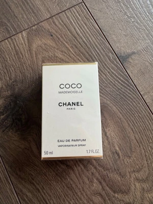 Chanel Coco Mademoiselle EdP 50ml - Chanel Coco Mademoiselle Eau de Parfum i en elegant, rektangulär vit och guldig kartong. Parfymen är 50 ml och kommer i en klassisk förpackning med stilren design. Perfekt för dig som gillar lyxiga och ikoniska dofter. Aldrig använd och helt ny såklart. Självklart äkta 