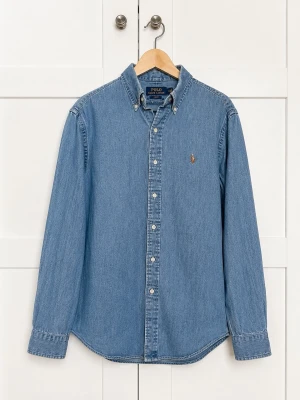 Blå jeansskjorta från Polo Ralph Lauren - Klassisk blå jeansskjorta från Polo Ralph Lauren med broderad logga på bröstet. Skjortan har lång ärm, knappar framtill och en avslappnad passform. Perfekt till jeans eller chinos för en casual look.