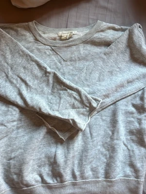 Grå sweatshirt Isabel Marant x H&M - Säljer en stilren grå sweatshirt från Isabel Marant pour H&M. Tröjan har rund halsringning, långa ärmar och ribbade muddar vid ärmslut och nederkant. Perfekt basplagg i mjukt material, passar till allt och är enkel att styla.