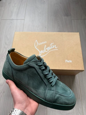 Rantulow Orlato Flat - Christian Louboutin sneakers i färgen Verveine vilket motsvarar en mörk grön. Extremt fint skick och endast använda ett tiotals gånger. Vid köp medföljer även skolåda, dustbags och nya orginal snören. Storlek 44 1/2, vid intresse be gärna om innermått.