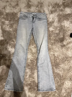 Ljusgrå bootcut jeans - Snygga ljusgrå bootcut jeans med låg midja. Jeansen har en lätt tvättad look och är tillverkade i ett stretchigt denimtyg. Säljs pga: lite korta för mig som är 170.
