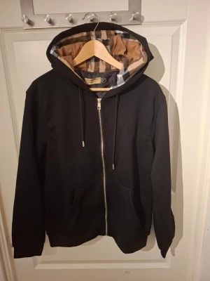 Svart hoodie - Svart hoodie med beige luva, aldrig använd, passar M, pris går att diskutera