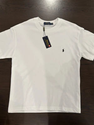 White t-shirt  - Plain white t-shirt with a dark blue logo, in the size M. 