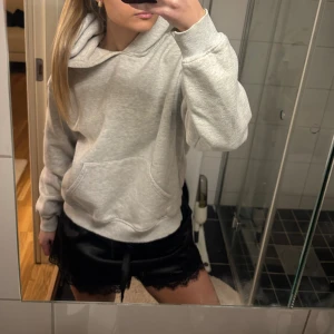 Ljusgrå hoodie med huva - Säljer en ljusgrå hoodie med stor huva och magficka. Hoodien har en avslappnad passform och ribbade muddar vid ärmar och nederkant. Perfekt för en chill och casual look.