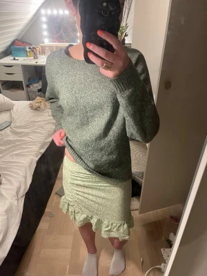 Ljusgrön volangkjol med småblommigt mönster - Supersöt ljusgrön kortkjol med småblommigt mönster och volangkant nertill. Kjolen har en figurnära passform och är perfekt för vår och sommar. Materialet känns lätt och luftigt, vilket gör den bekväm att bära hela dagen. Säljer den då den inte kommer till användning längre. kontakta mig om ni har frågor💕