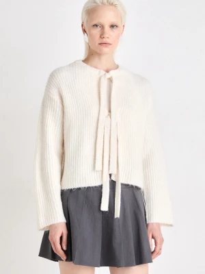 Vit ribbstickad kofta med knytband - Superfin vit ribbstickad kofta med långa ärmar och knytband framtill. Koftan har en rak, något kortare passform och är gjord i ett mjukt, fluffigt material som känns lyxigt. Perfekt att slänga över en topp för en chill look.