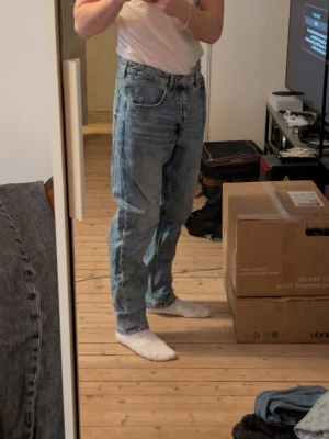 Ljusblå raka jeans  - Säljer ett par klassiska ljusblå jeans med rak passform och hög midja. Jeansen har fem fickor, gylf med dragkedja och knapp samt tydliga tvättade detaljer för en avslappnad look. Perfekta till en enkel t-shirt eller hoodie.