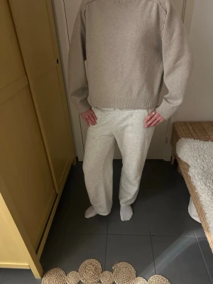 Ljusgrå mjukisbyxor med raka ben - Säljer ett par ljusgrå mjukisbyxor med raka ben och resår i midjan. Byxorna har en avslappnad passform och är tillverkade i ett mjukt och bekvämt material, perfekt för chill dagar. Fickor på sidorna och baktill för extra funktion.