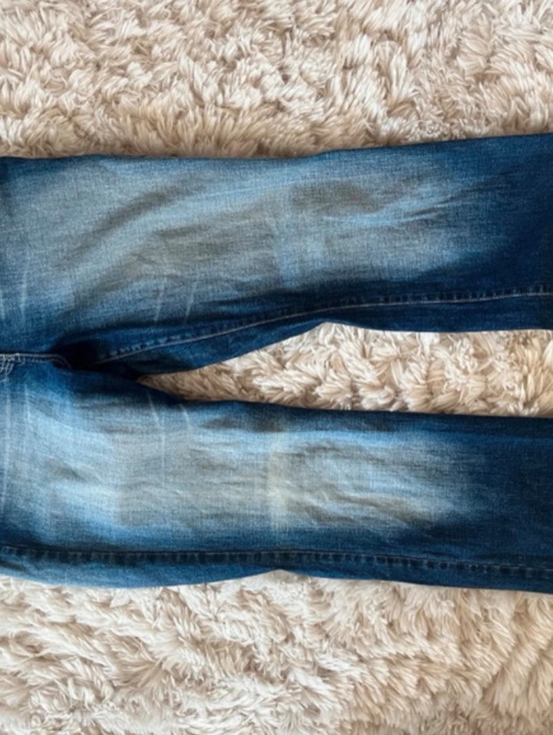 Blå jeans med dekorerade bakfickor