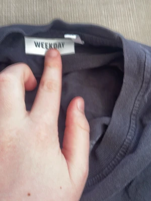 Scout t-shirt. Svart t-shirt från Weekday - Säljer en svart t-shirt från Weekday med tryck på bröstet där det står 'Landskrona scoutkår' och en grafisk illustration. Klassisk rund hals och korta ärmar. Perfekt för dig som gillar enkel och stilren design.