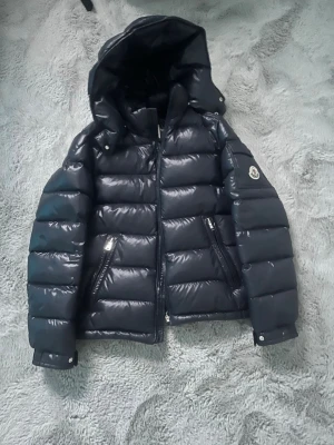 Moncler Maya 12y - Navy blå/mörkblå Moncler Maya i stl 12y(152cm). Själv är jag 160 och den passar fortfarande på mig så skulle säga från 145-162. Går såklart om man är ännu mindre en 145. Köpt på nk jan 2024. Digitalt kvitto från nk kan skickas med! Hör av er vid funderingar.