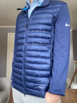Nike Golf Jacka – Navy – Strl M – AeroLoft - Nike AeroLoft golfjacka. Lätt, varm och flexibel.  • Märke: Nike • Modell: AeroLoft • Storlek: M • Färg: Navy • Skick: Fint skick  📦 skickas samma dag ⚡ Snabb affär prioriteras 