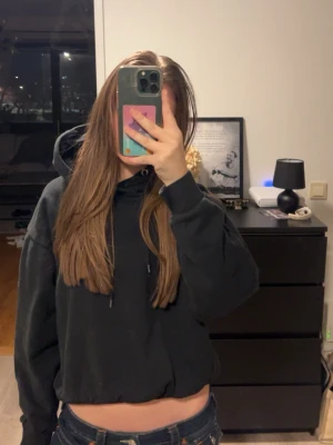 Svart hoodie med huva - Säljer en svart hoodie med huva och dragsnören. Hoodien har en avslappnad passform och långa ärmar, perfekt för en chill och stilren look. Passar till jeans eller mjukisbyxor 